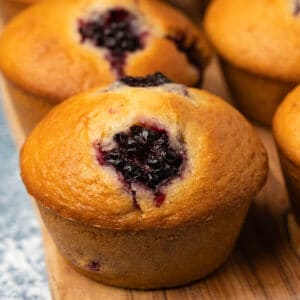 Vegan blackberry muffins on a wooden board.