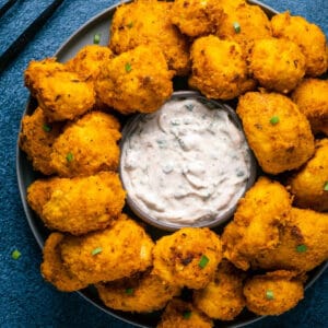 Vegan buffalo cauliflower on a plate with vegan ranch dressing.