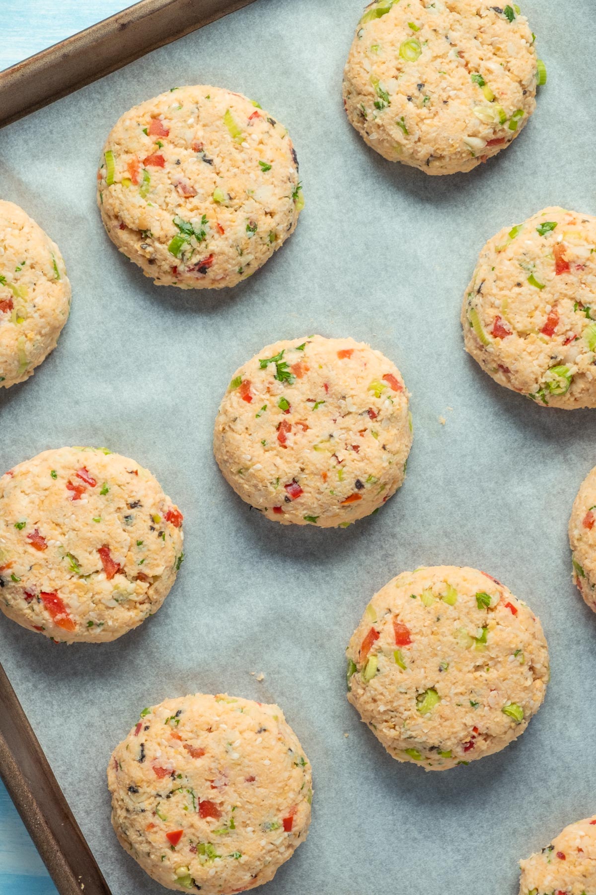 Uncooked vegan crab cakes on a parchment lined tray.