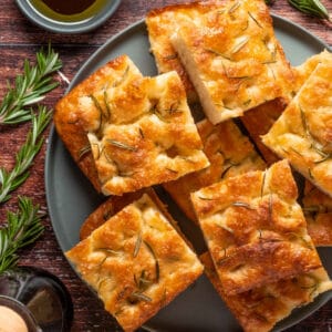 Vegan focaccia stacked up on a blue plate.