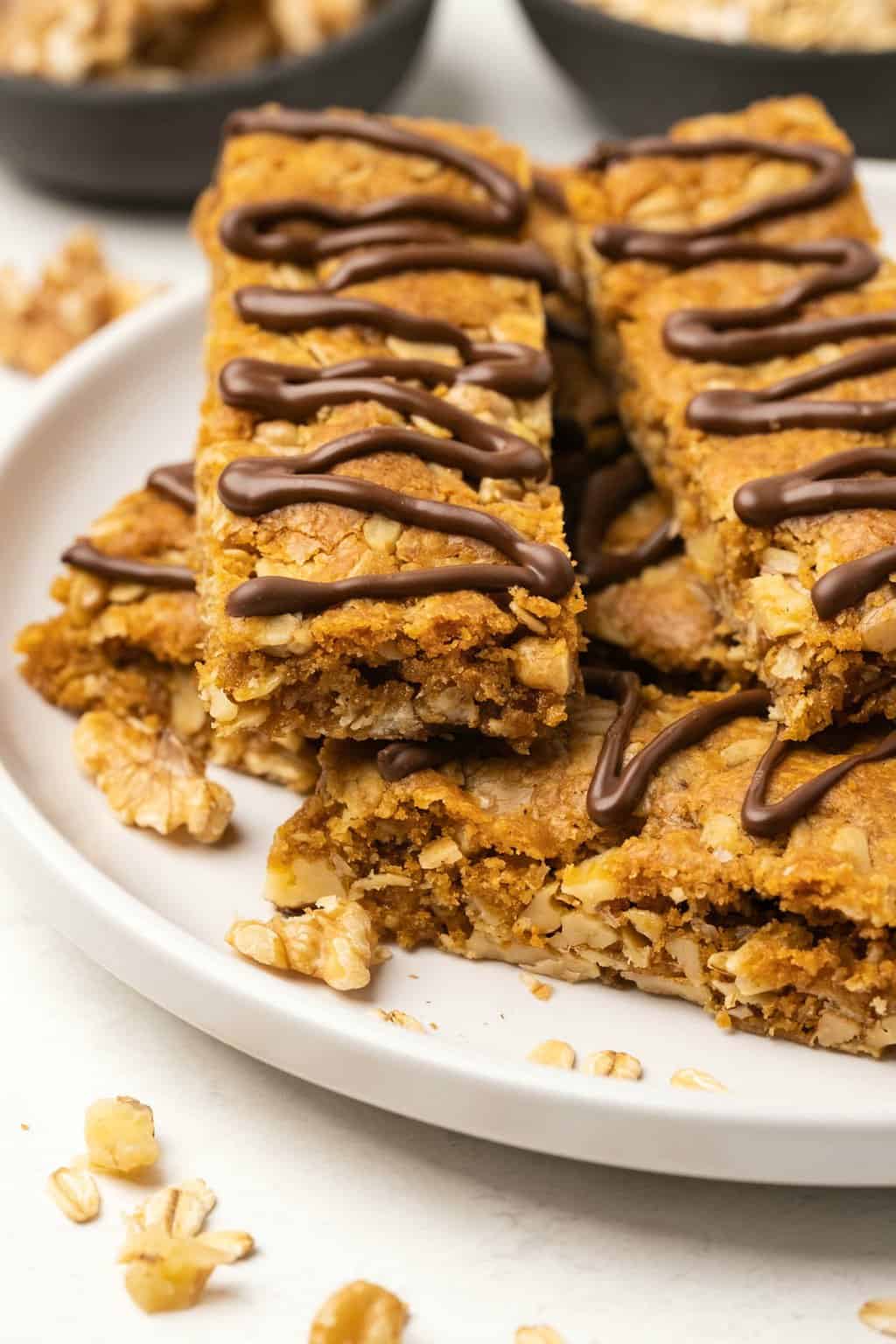 Vegan oatmeal bars stacked up on a white plate. 