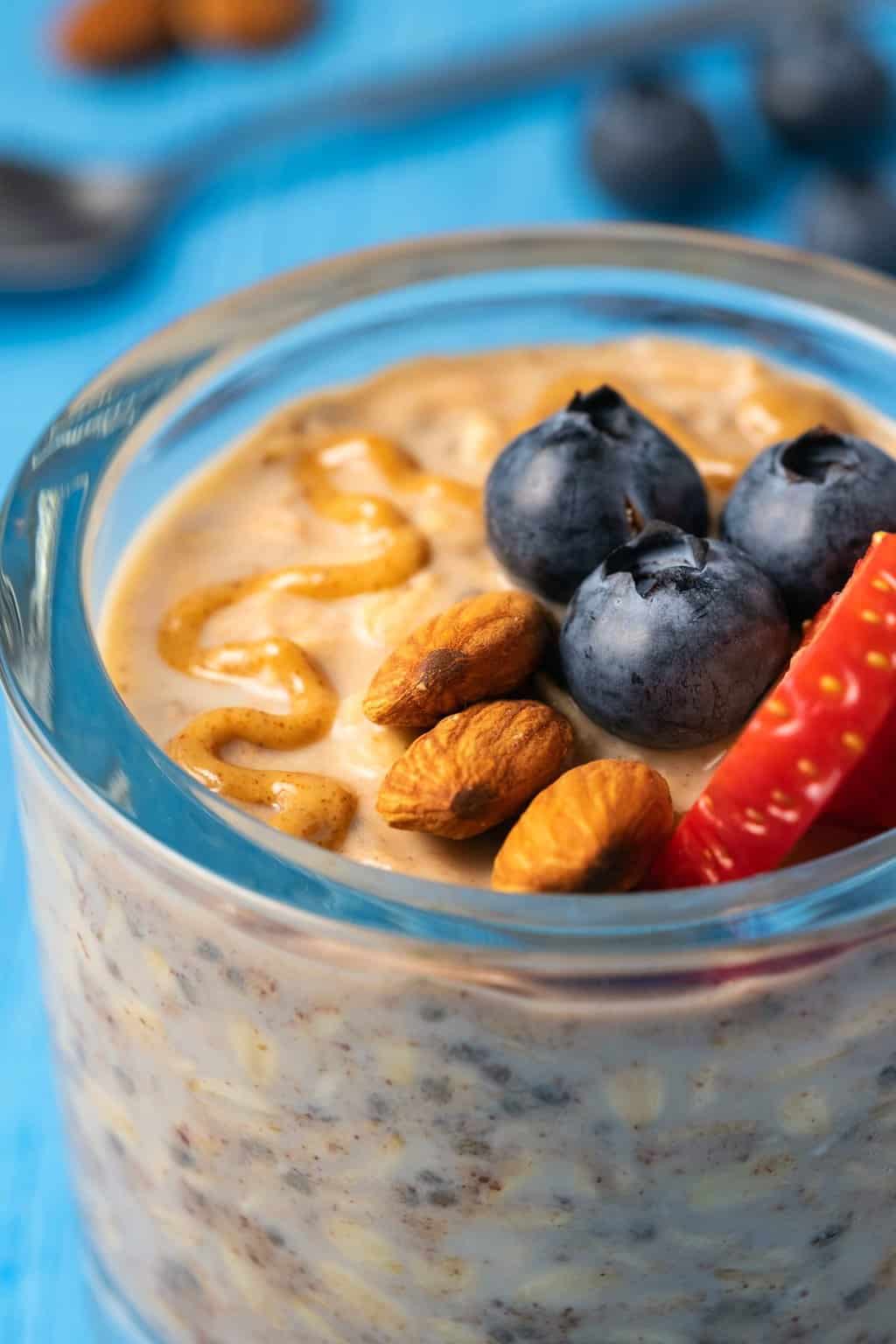 Vegan overnight oats topped with fresh fruit in a glass jar. 