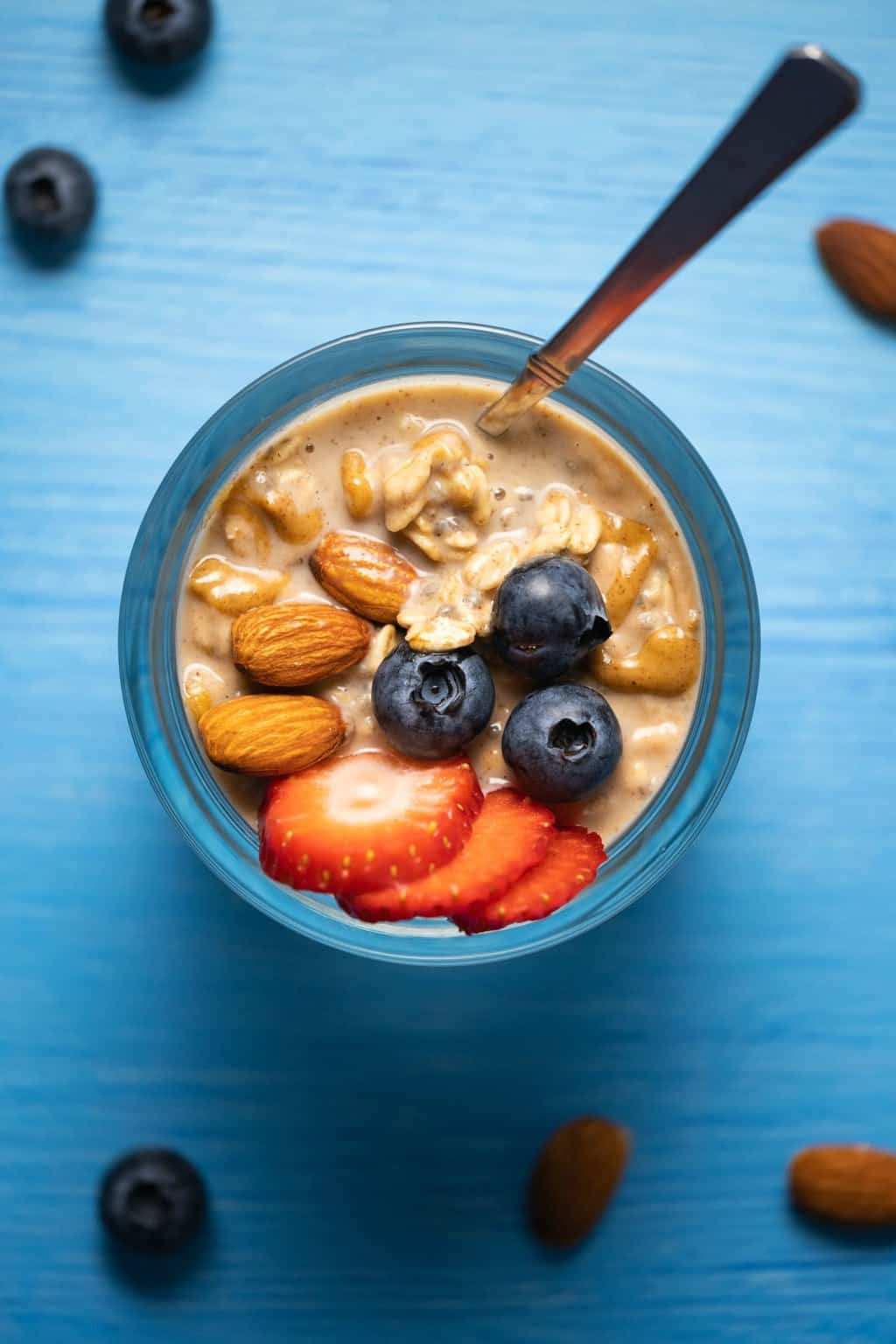 Vegan overnight oats in a glass jar with a spoon. 